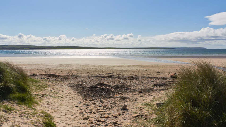 Sand dunes and calm waters at Dunnet Bay beach