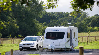 Car and caravan by fenced field