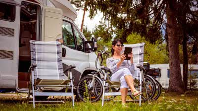 woman using a tablet outside her motorhome